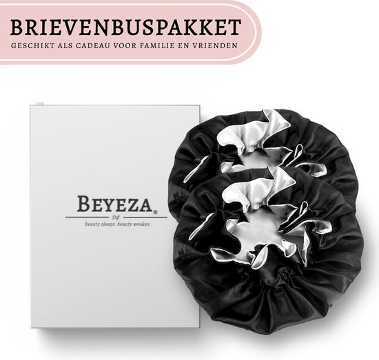 Twee zwarte satijnen slaapmutsen naast een witte cadeauverpakking van Beyeza.