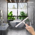 Main avec une raclette de douche en acier inoxydable nettoyant une fenêtre de salle de bain mouillée.