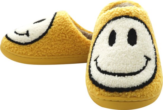 Gele fuzzy pantoffels met opdruk van een witte smiley met zwarte ogen en mond.