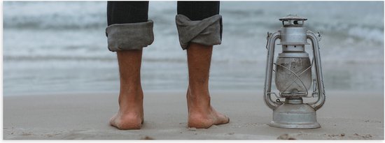 WallClassics - Poster (mat) - Pieds sur la plage avec lanterne - 120x40 cm Photo sur papier poster avec un aspect mat