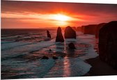 WallClassics - PVC Schuimplaat- Rotsen in de Zee met Zonsondergang - 150x100 cm Foto op PVC Schuimplaat