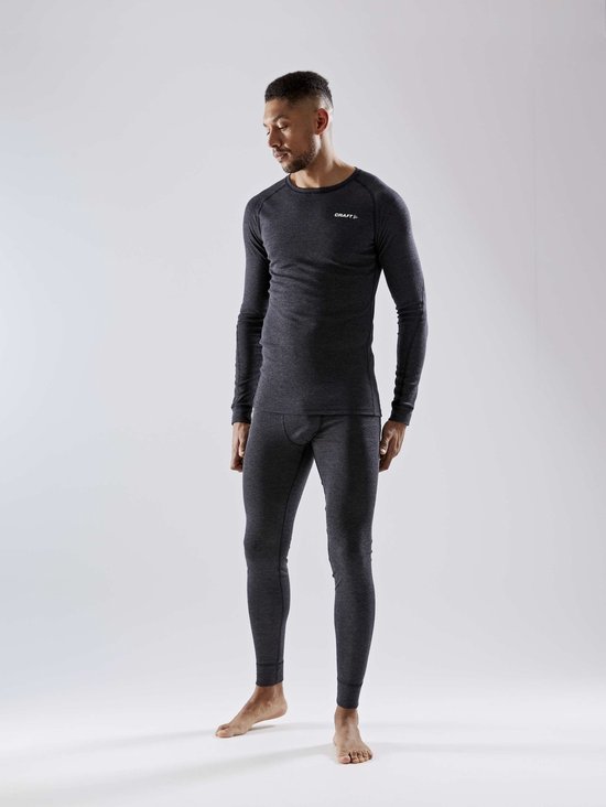 Model in donkere antraciet thermobroek en thermoshirt met zwarte tailleband.