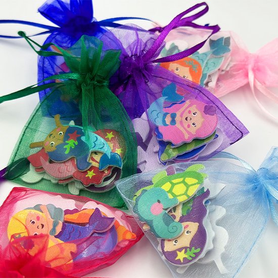 Vijf organza zakjes met foam zeemeermin stickers in rood, groen, paars, lichtblauw en blauw.