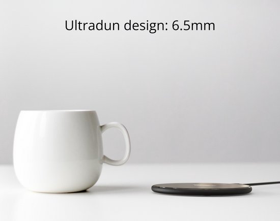 Een witte mok naast een ultradunne zwarte draadloze oplader van 6,5 mm.