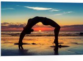 PVC Schuimplaat - Vrouw in Yoga Positie op het Strand bij Ondergaande Zon - 75x50 cm Foto op PVC Schuimplaat (Met Ophangsysteem)
