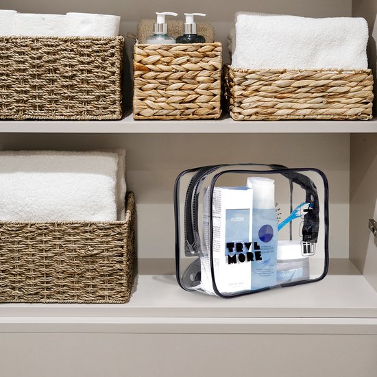 Transparante toilettas met toiletartikelen op een plank met handdoeken en manden.