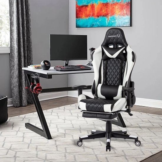 Zwarte en witte gamingstoel met geruite bekleding, nekkussen en uitschuifbare voetsteun in een kantoorruimte.