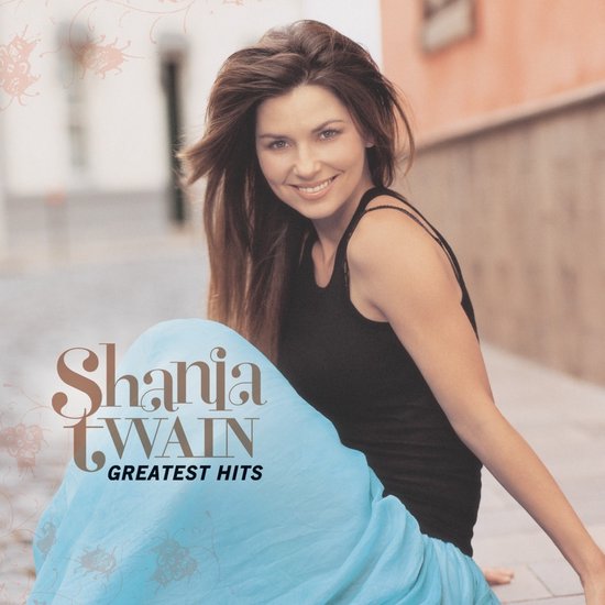Shania Twain op de hoes van "Greatest Hits". Ze draagt een zwarte top en een lichtblauwe rok.