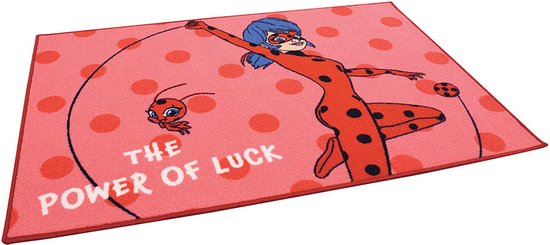 Tapis avec Ladybug et Tikki sur fond rose à pois rouges. Il est écrit 'The Power of Luck'.