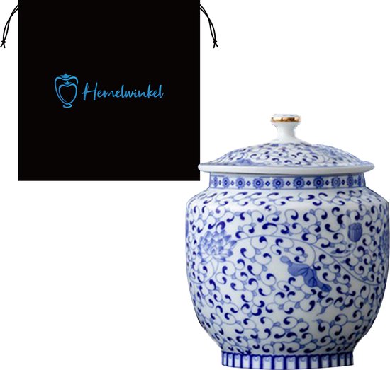 Blauw-witte porseleinen urn met bloemenpatroon, naast een zwarte stoffen zak met logo.