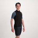 Man, van voren gezien, in zwart fietsjack en grijs shirt, met zwarte fietsbroek.