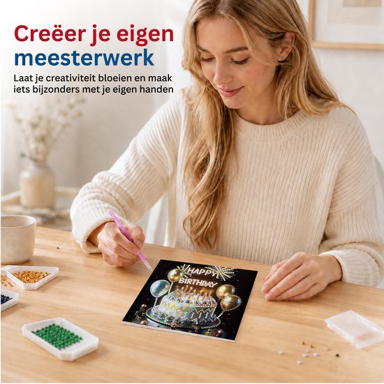 Vrouw met lichte trui maakt diamond painting 'Happy Birthday' kaart met taart, ballonnen en diamanten.