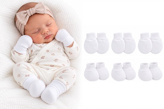 Pasgeboren baby draagt witte wantjes en slofjes met een bloemenromper en strik. Inclusief zes paar witte wantjes.