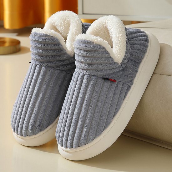 Chaussons gris côtelés avec doublure en fausse fourrure blanche et semelle blanche épaisse.