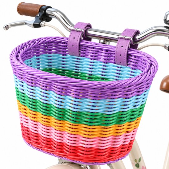 Gekleurd fietsmandje met regenboogpatroon in paars, blauw, groen, geel, oranje, roze en rood, bevestigd aan een fietsstuur met bruine handvatten.