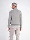 Achteraanzicht van de grijze polo met verticale strepen en textuur, gecombineerd met een beige broek.