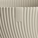 Close-up van een Mushroom beige Elho bloempot met verticale ribbels en het Elho logo.