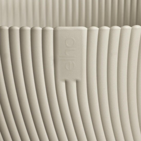 Close-up van een Mushroom beige Elho bloempot met verticale ribbels en het Elho logo.