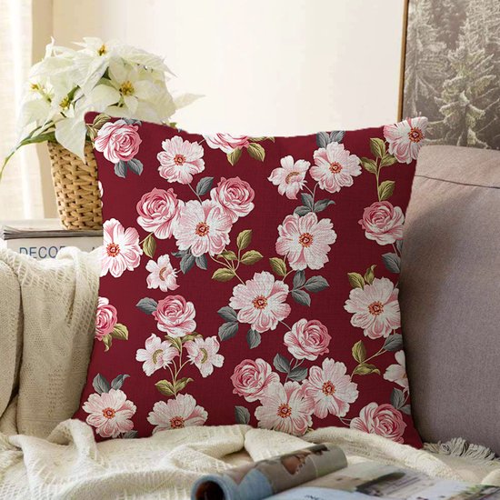 Bordeauxrode sierkussenhoes met een doorlopende print van roze en witte bloemen.