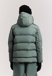 Jongen in grijze winterjas en skibroek. Zwarte muts en handschoenen. Achteraanzicht.