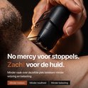 Hand houdt een zwart Viking Mini scheerapparaat tegen de nek van een man. 'No mercy voor stoppels. Zacht voor de huid.'
