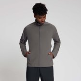 Model draagt grijze sportjas met rits en zwarte broek, handen in de zakken.