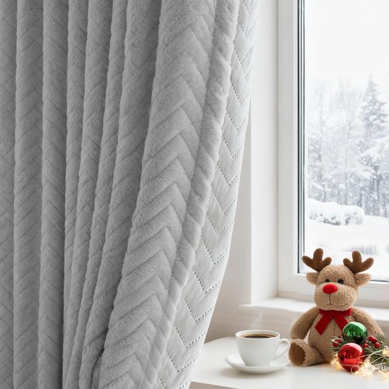 Lichtgrijze pluche gordijnen met visgraatpatroon, naast een raam met sneeuw en een rendierknuffel.