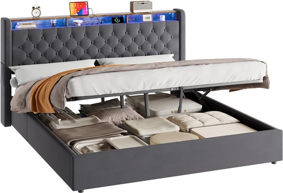 Donkergrijs gestoffeerd bed met capitonnering in het hoofdbord, houten legplanken met LED-verlichting en opbergruimte onder de bedbodem.