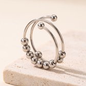 Zilverkleurige verstelbare ring van roestvrij staal met schuifbare kraaltjes op een licht stenen oppervlak.
