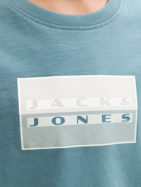 Close-up van witte rechthoekige print met stippenpatroon en tekst Jack & Jones op blauw t-shirt.