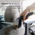 Hand met gouden armband gebruikt een stoomreiniger op een stoffen autostoel, deels zichtbaar in een auto. Tekst: Schoon tot in elke vezel.