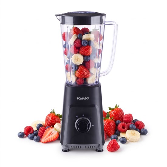 Zwarte Tomado blender gevuld met aardbeien, bosbessen, frambozen en bananen. Omringd door meer fruit.