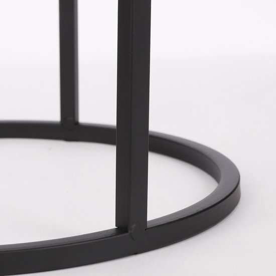 Gedetailleerd zicht op de ronde metalen basis en de poten van een zwart bijzettafeltje.