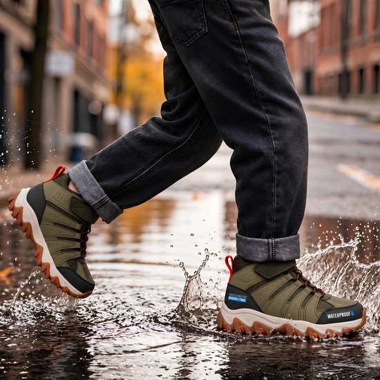 Olijfgroene Skechers SKECH-TEK veterboots met 'WATERPROOF' tekst, gedragen door iemand die door een plas loopt.