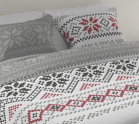 Dekbedovertrek met een Scandinavische breipatroon in grijs, wit en rood. Een kussen heeft een rode sneeuwvlok, het andere een grijs patroon.