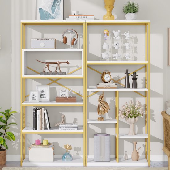 Gevulde open boekenkast met gouden frame, witte schappen, en decoraties zoals een radio en beeldjes.