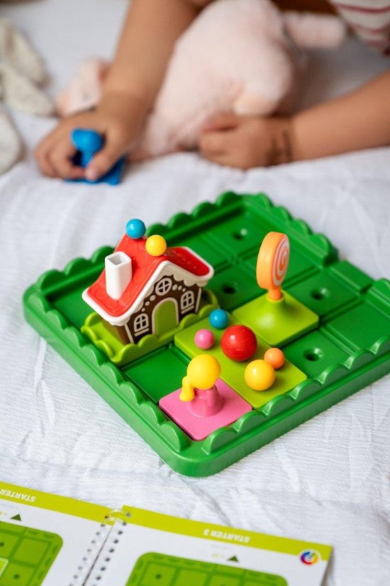 Groene speelplaat met gingerbread huisje, een snoepjespuzzel en een kind dat speelt.