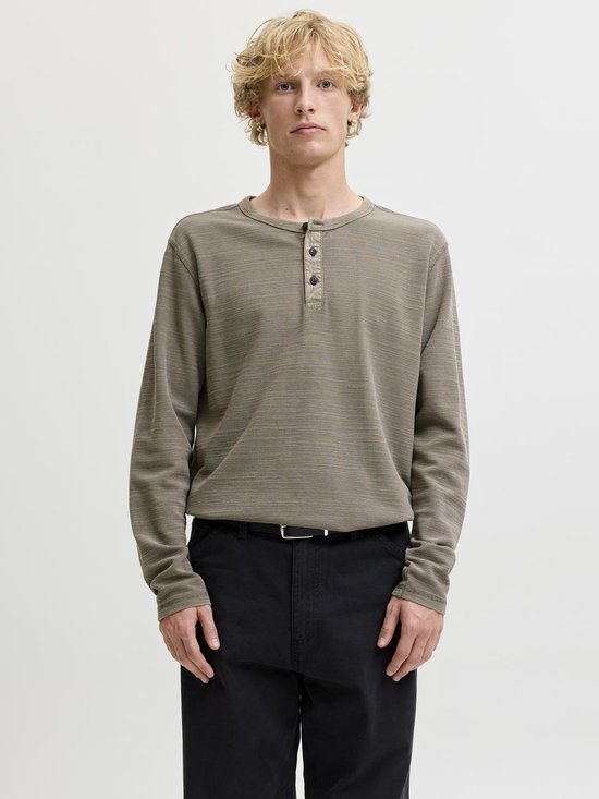 Man met donkerbruine longsleeve henley met knoopjes en wafeltextuur.