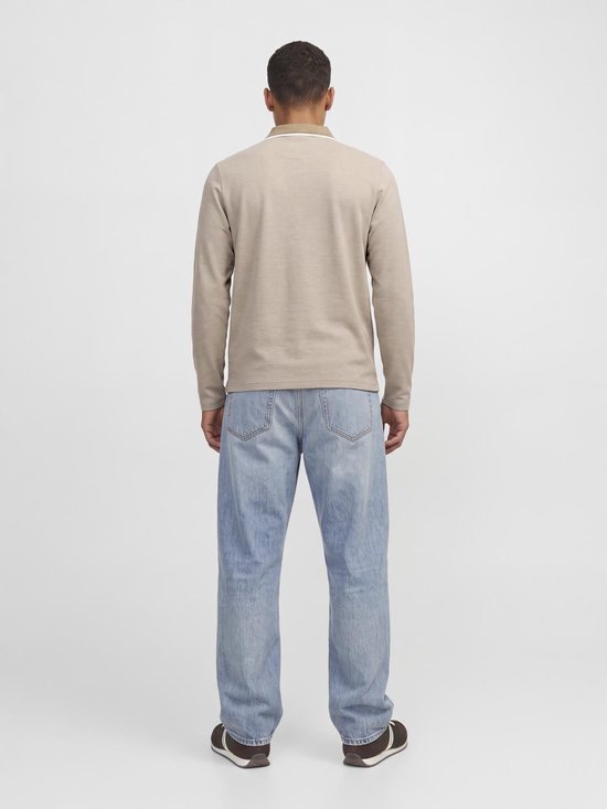 Achterkant van man in beige poloshirt met lange mouwen en lichtblauwe jeans tegen een witte achtergrond.