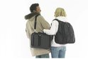 Man en vrouw lachen, elk dragend een zwarte Kensington tas, een laptoptas over de schouder en een rugzak.