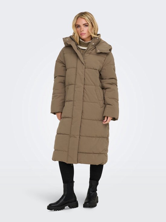 Een vrouw met blond haar draagt een lange, bruine pufferjas met capuchon.