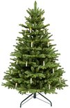 Volle, realistische kunstkerstboom met verlichte LED-kaarsjes op een groene metalen standaard.