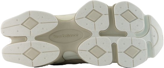 Onderkant van een lichtbruine New Balance 9060 dames sneaker, met "new balance" logo.