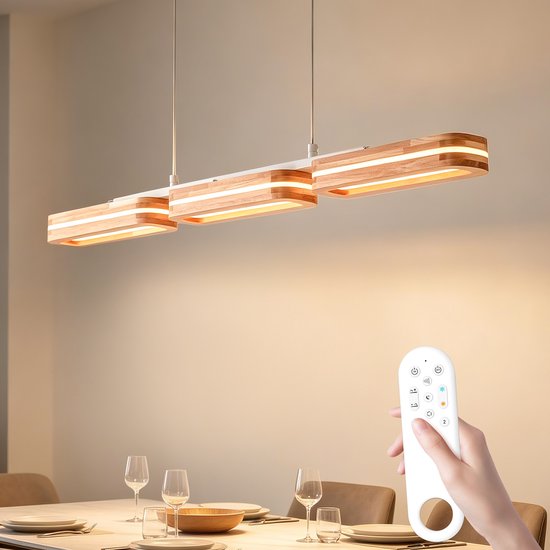Hand houdt afstandsbediening vast, gericht op hanglamp met drie houten rechthoekige elementen.