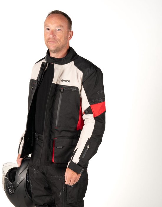 Motorjas met zwarte, crèmekleurige en rode vlakken, met DXR-logo's. Een man draagt de jas en houdt een helm vast.