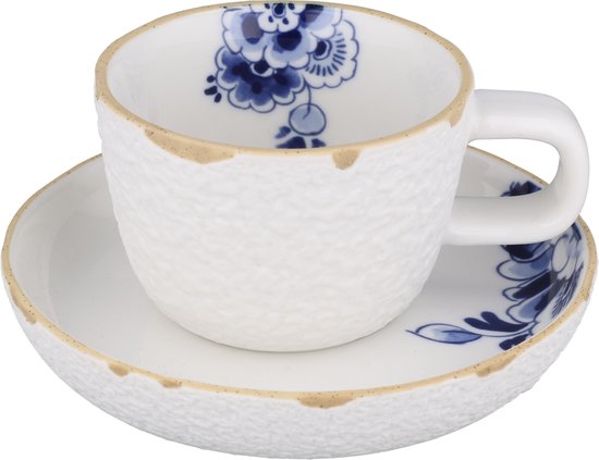 Koffiekop en schotel met wit gestructureerd oppervlak en blauw Delfts bloemmotief.