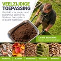 Persoon duwt een kruiwagen vol aarde; geschikt voor zand, hout, puin, bladeren en graszoden.