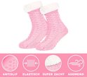 Roze gebreide huissokken met kabelpatroon, witte fleece voering en antislip zolen. Gemarkeerd als 'Antislip', 'Elastisch', 'Super Zacht', 'Ademend'.