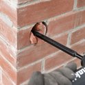 Een Makita-beitel verwijdert het binnenste van een gat in een bakstenen muur.