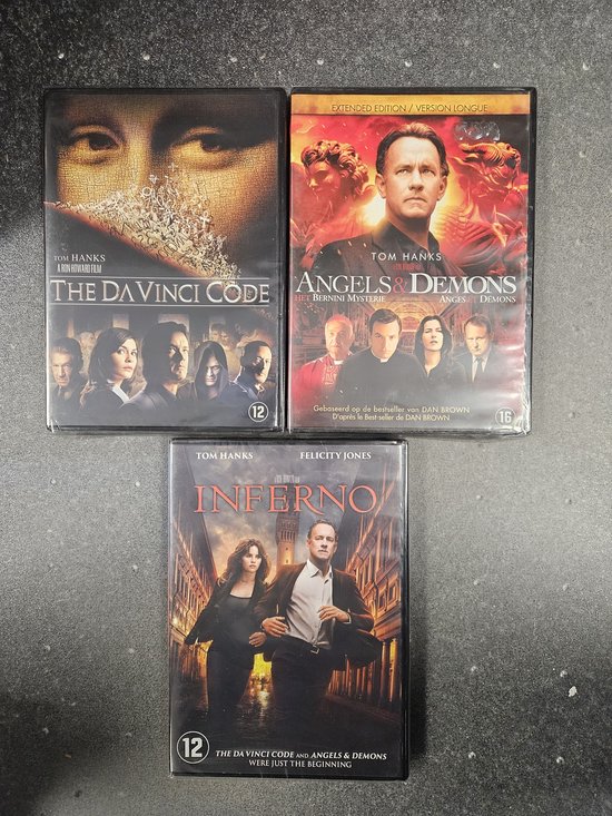 Drie dvd-hoezen van de Dan Brown-films: Angels & Demons, The Da Vinci Code en Inferno met Tom Hanks.